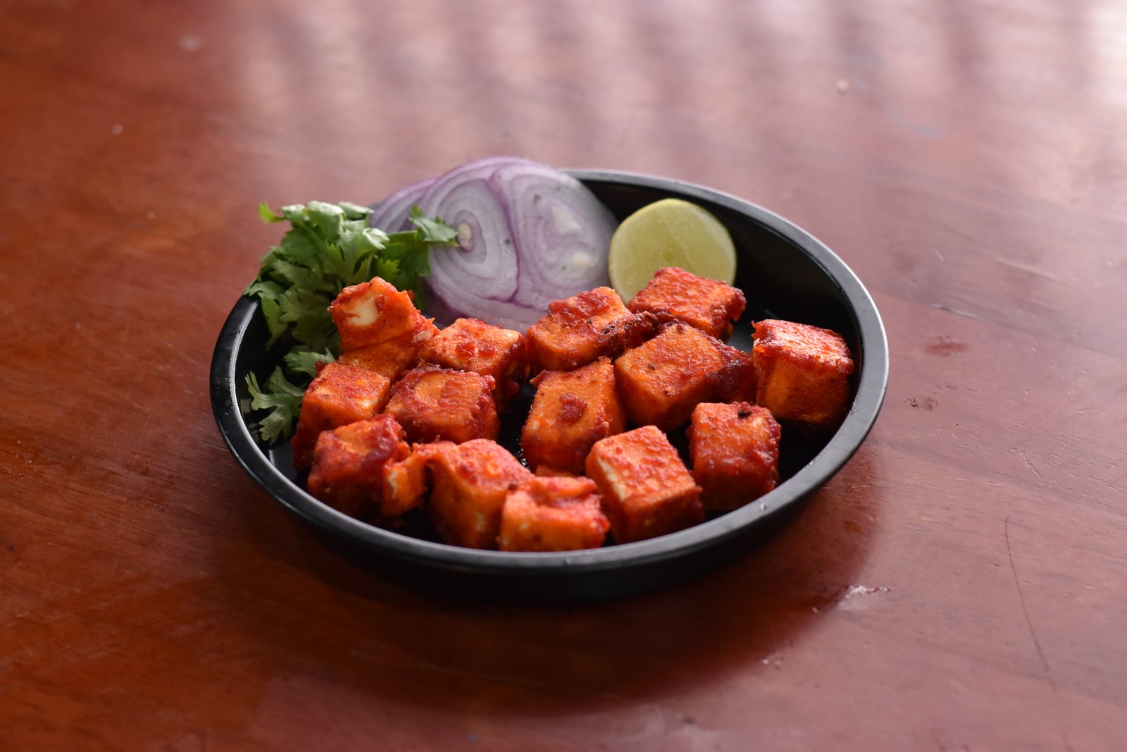 Paneer 65 in a black dish